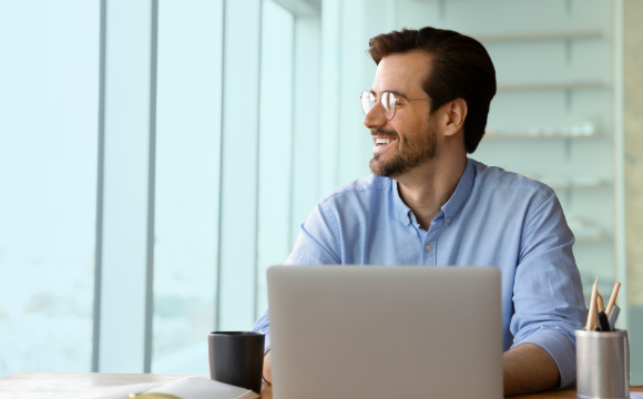 Happy retail lease manager looking out the window sitting at desk