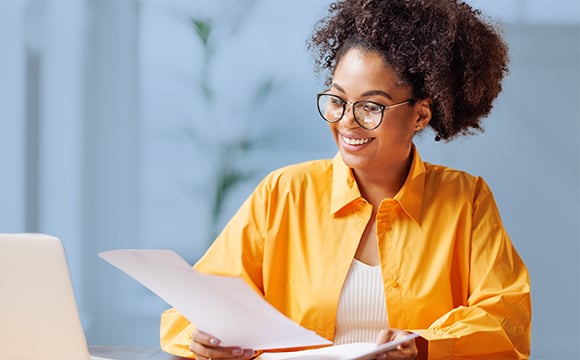 Smiling African American lease accountant looking at some papers at her desk