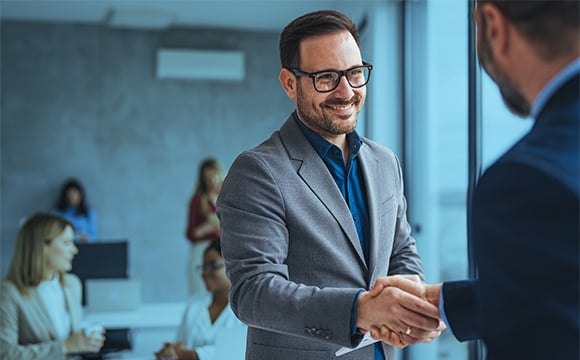 Male commercial real estate professional shakes hands with lease administrator